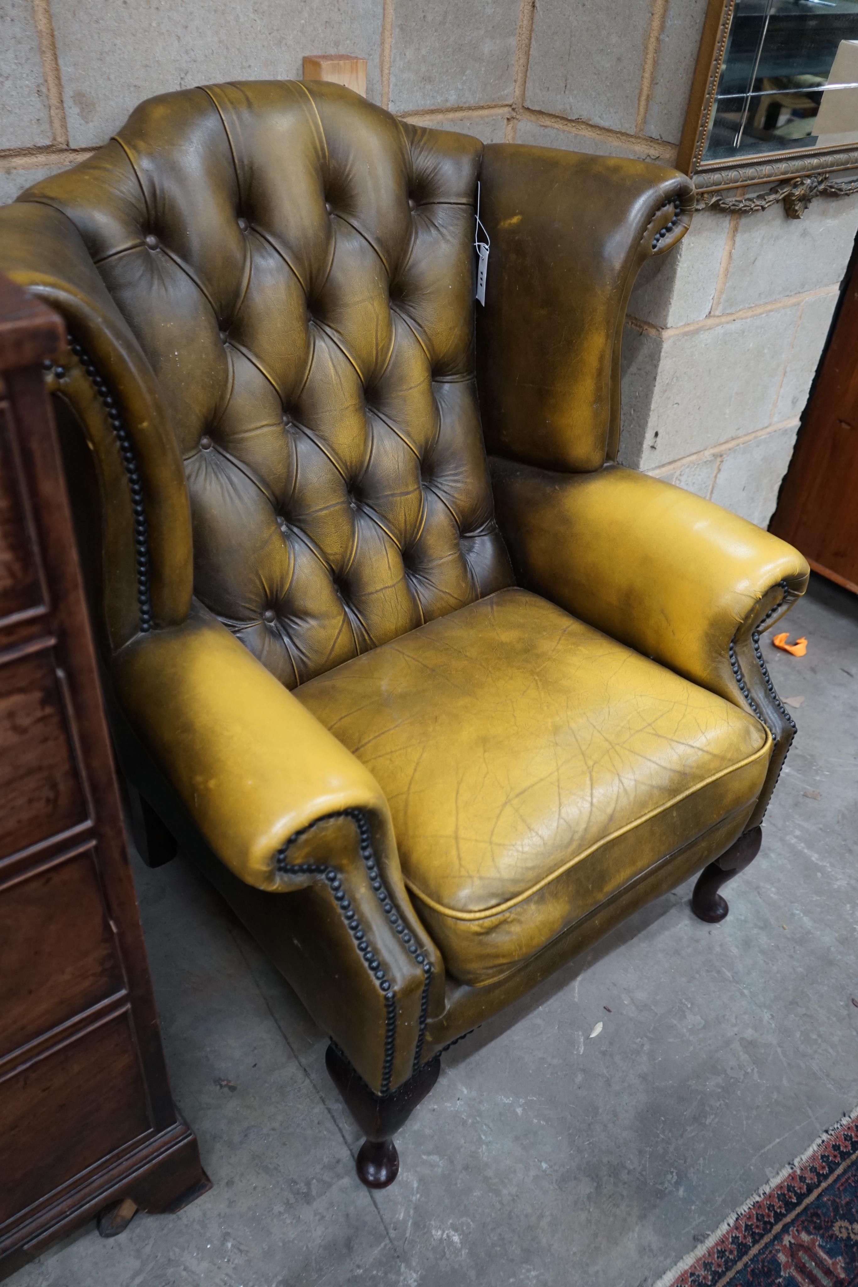 A Victorian style green leather wing armchair, width 82cm depth 76cm height 100cm